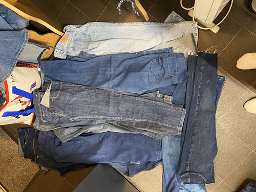Donated Denim Jeans on the floor waiting to be used in the pieces