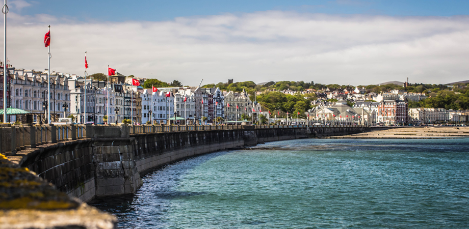Image of Victorian Townhouses sitting on the promenade overlooking Douglas beach on a sunny day. 